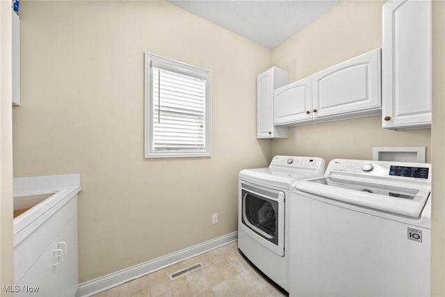 laundry area featuring cabinet space, washing machine and dryer, visible vents, and baseboards