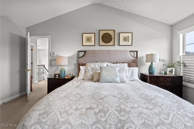 carpeted bedroom with baseboards and lofted ceiling