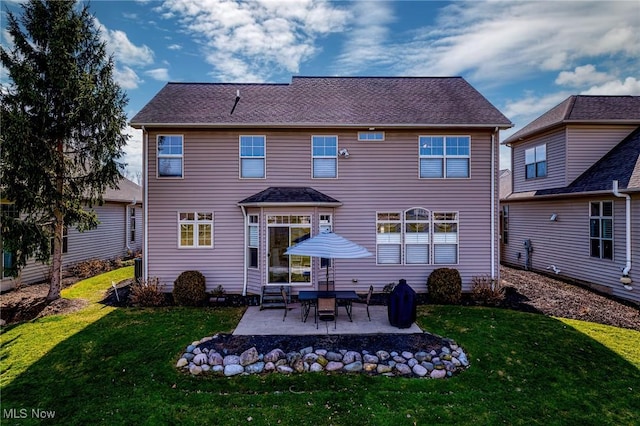 rear view of house with a lawn, entry steps, and a patio