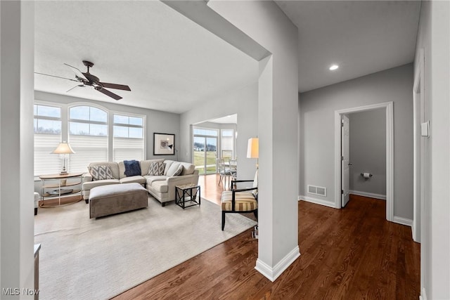 living area featuring visible vents, dark wood-type flooring, baseboards, recessed lighting, and a ceiling fan