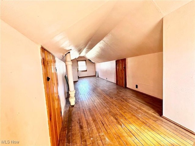 bonus room with wood-type flooring and lofted ceiling