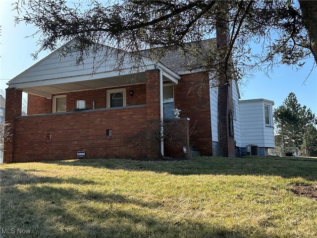 view of property exterior with a chimney, a lawn, central AC unit, and brick siding