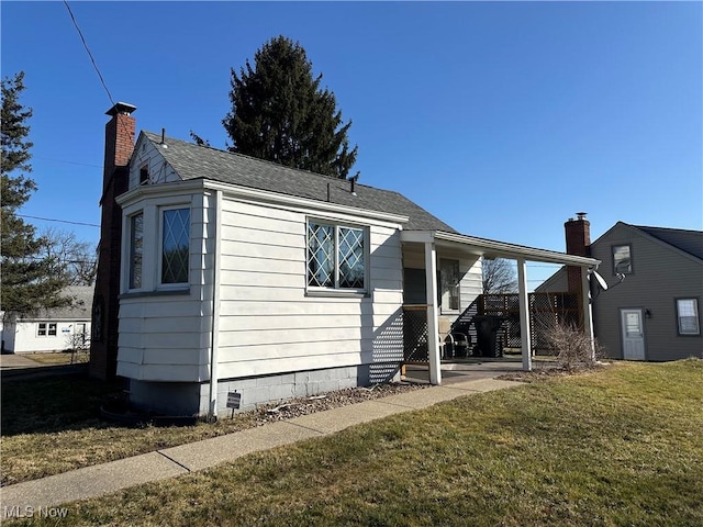 view of home's exterior with crawl space, a lawn, and a chimney