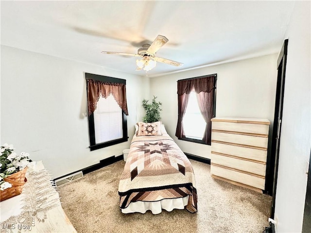 bedroom with visible vents, baseboards, and ceiling fan