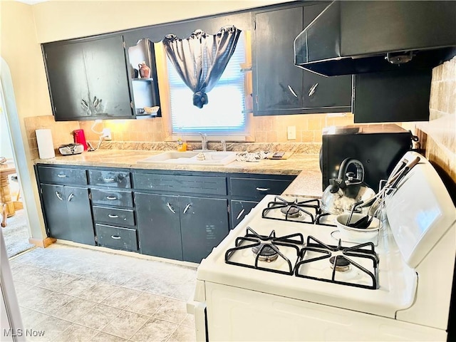 kitchen with tasteful backsplash, a sink, under cabinet range hood, white range with gas cooktop, and open shelves