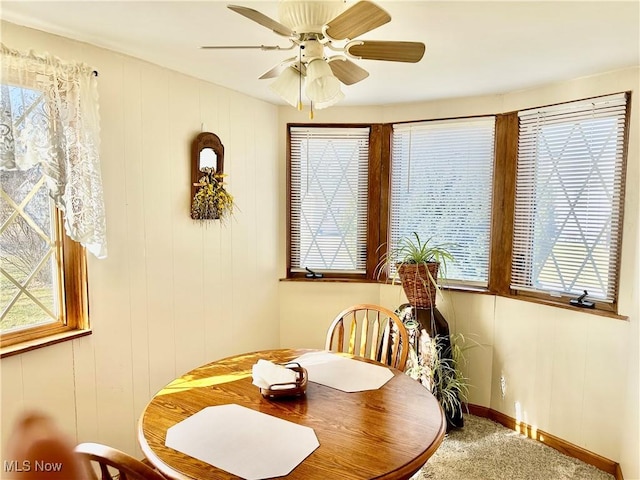 dining area featuring carpet flooring, baseboards, and ceiling fan