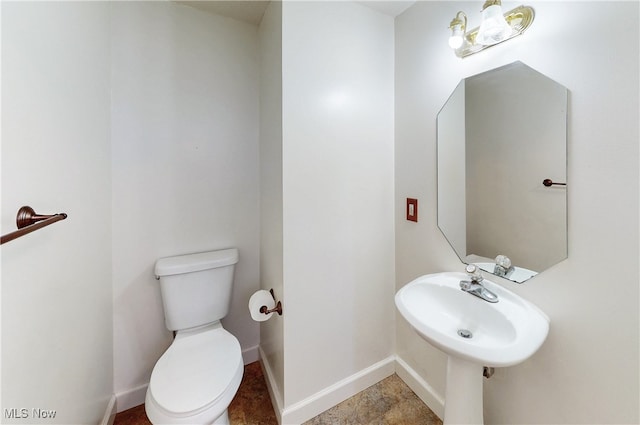 half bathroom with toilet and baseboards