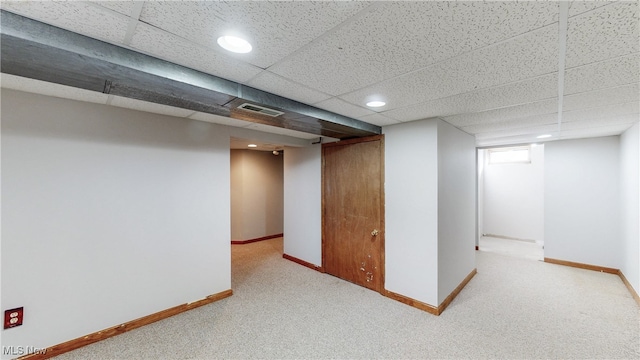 finished basement with visible vents, carpet flooring, baseboards, and a drop ceiling