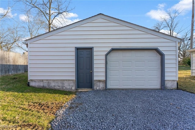 detached garage with gravel driveway and fence