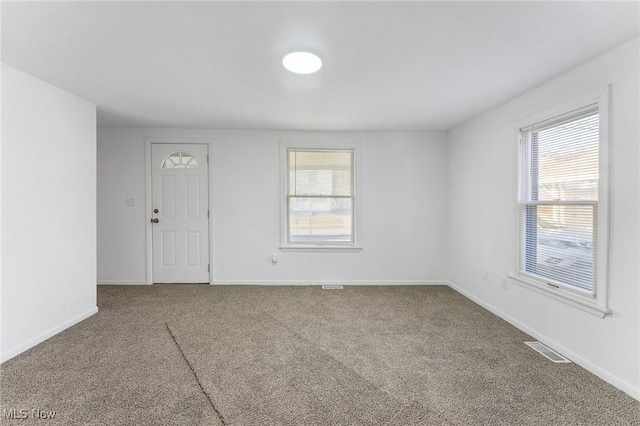 carpeted empty room with baseboards and visible vents