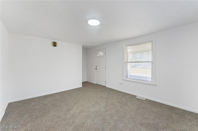 carpeted empty room with visible vents and baseboards