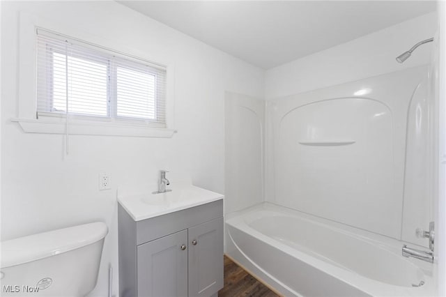 bathroom featuring shower / bath combination, toilet, vanity, and wood finished floors