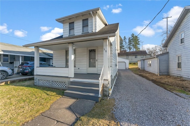 view of front of property with an outbuilding, a porch, a front yard, and a shingled roof