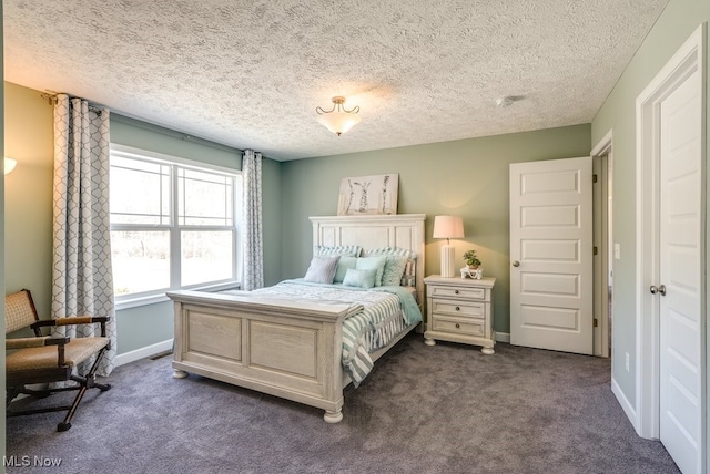 bedroom with baseboards, a textured ceiling, and dark carpet