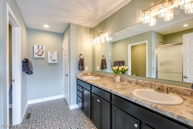 full bathroom with a sink, baseboards, and a stall shower