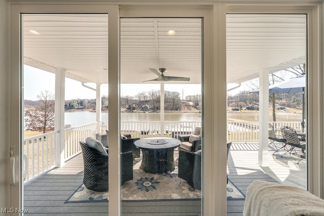 interior space with plenty of natural light, ceiling fan, and a water view