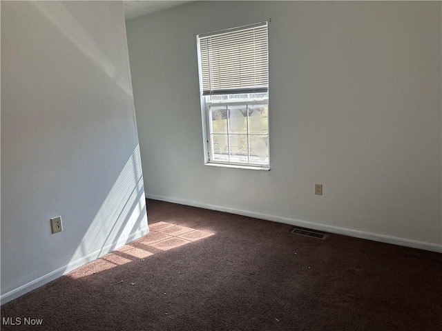 spare room featuring visible vents, baseboards, and carpet