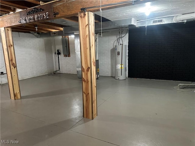 unfinished basement featuring electric panel, visible vents, water heater, and brick wall