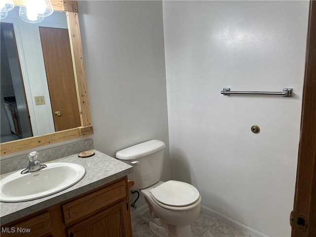 bathroom featuring vanity, tile patterned floors, and toilet