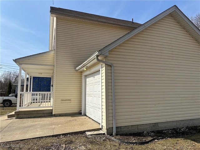 view of side of home featuring a porch and an attached garage