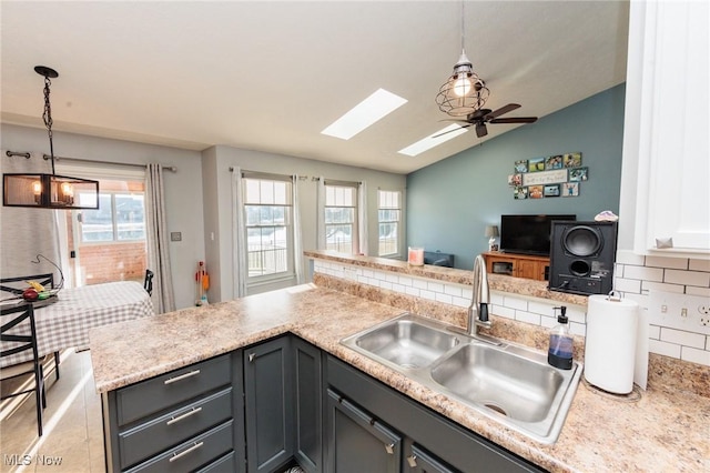 kitchen featuring a sink, plenty of natural light, open floor plan, and light countertops