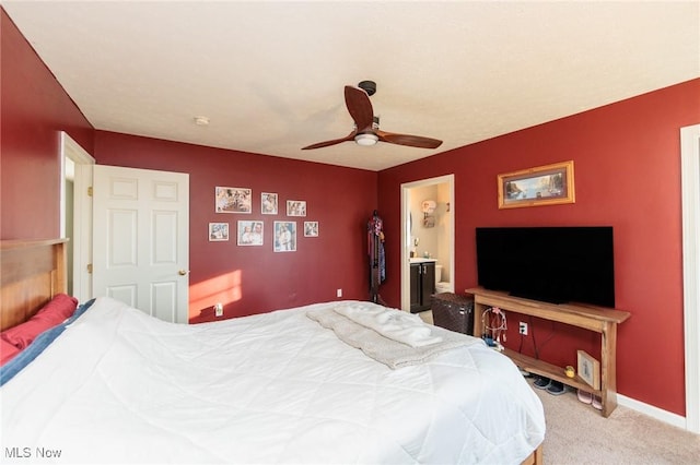 carpeted bedroom with a ceiling fan, ensuite bathroom, and baseboards