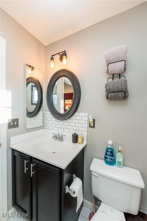 bathroom with vanity, toilet, and backsplash