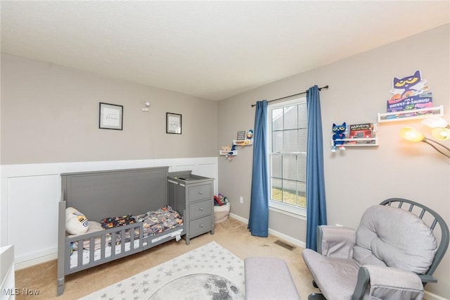 bedroom with multiple windows, baseboards, visible vents, and light carpet