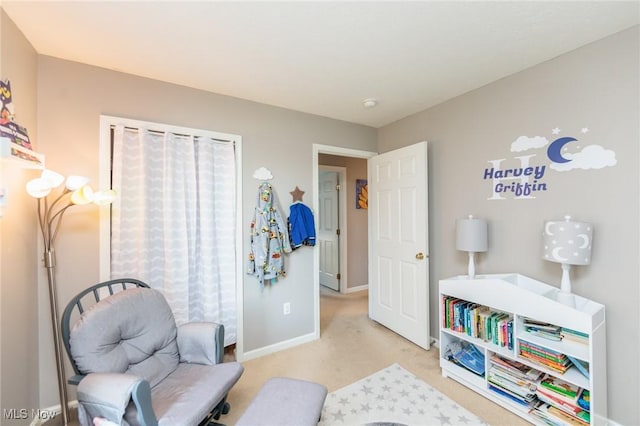 living area featuring carpet flooring and baseboards