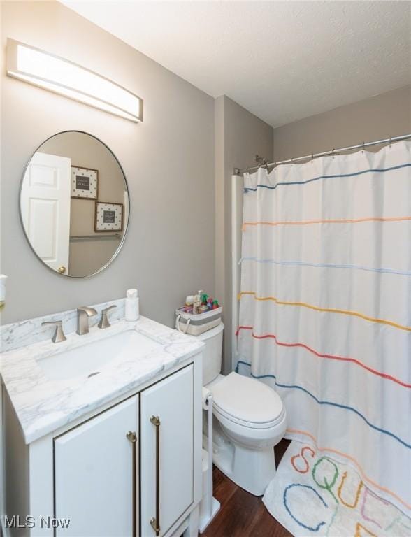 full bath featuring curtained shower, toilet, wood finished floors, and vanity