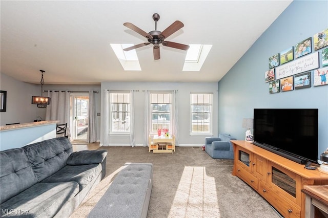 carpeted living room with lofted ceiling with skylight, a ceiling fan, and baseboards