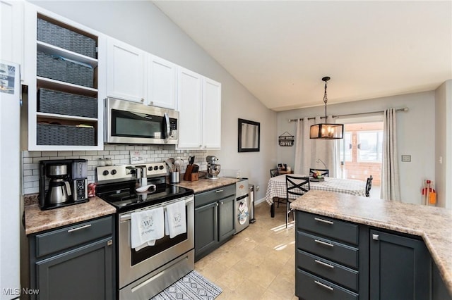 kitchen featuring white cabinetry, stainless steel appliances, light countertops, decorative backsplash, and vaulted ceiling