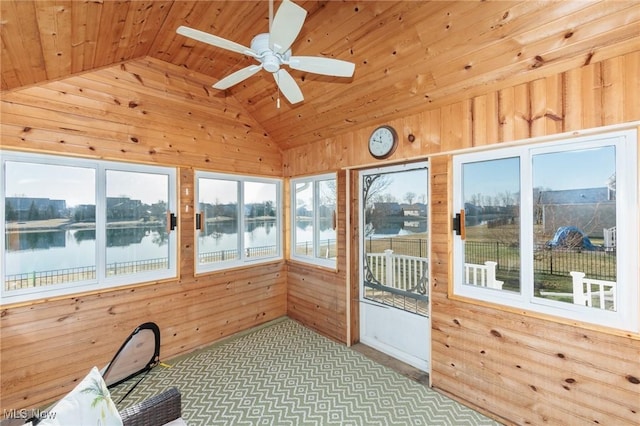 unfurnished sunroom featuring vaulted ceiling, wood ceiling, a ceiling fan, and a water view