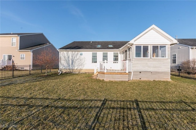 rear view of house featuring a yard, a deck, and fence