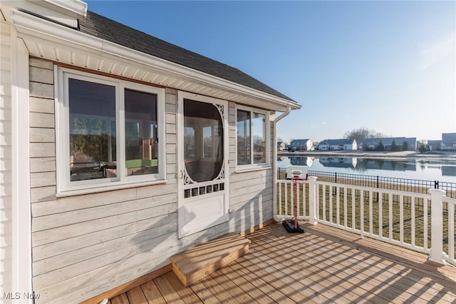 wooden deck featuring a water view and fence