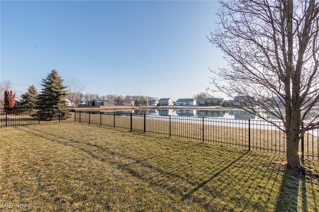 view of yard featuring a swimming pool, a water view, and fence