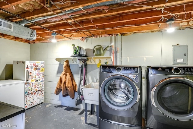 clothes washing area with laundry area, separate washer and dryer, visible vents, and a sink