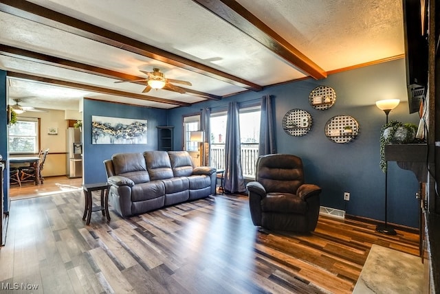 living room featuring plenty of natural light, visible vents, and ceiling fan