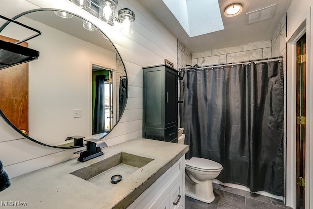 full bath featuring vanity, visible vents, vaulted ceiling with skylight, curtained shower, and toilet