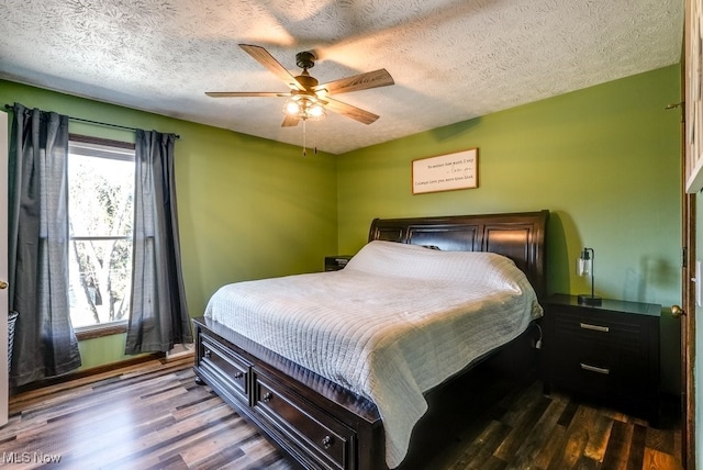 bedroom featuring dark wood-type flooring, ceiling fan, and a textured ceiling