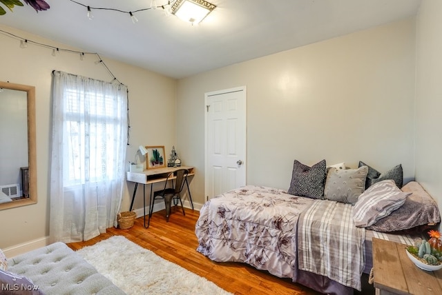 bedroom with baseboards and wood finished floors