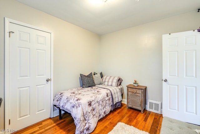 bedroom featuring visible vents and wood finished floors