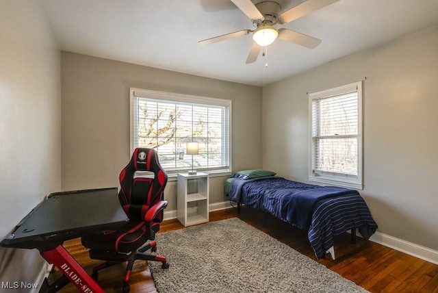 bedroom with a ceiling fan, baseboards, and wood finished floors