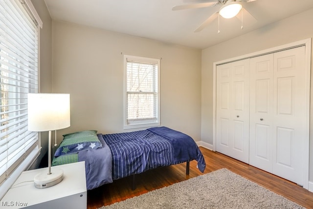 bedroom with a closet, baseboards, ceiling fan, and wood finished floors