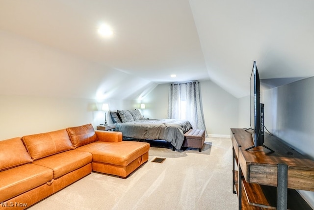 bedroom featuring visible vents, lofted ceiling, light colored carpet, and baseboards