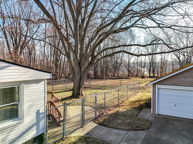 view of yard with a gate, fence, driveway, an outdoor structure, and a garage