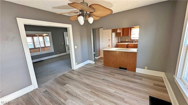 unfurnished dining area featuring visible vents, a ceiling fan, baseboards, and light wood finished floors