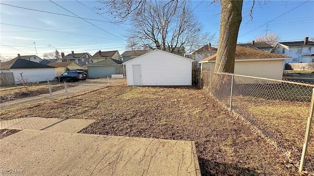 view of yard featuring an outbuilding, fence, a residential view, and a shed