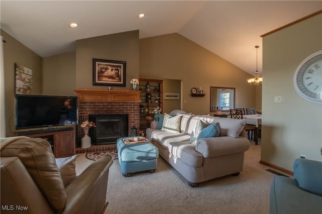 living area with visible vents, a brick fireplace, carpet floors, a notable chandelier, and high vaulted ceiling