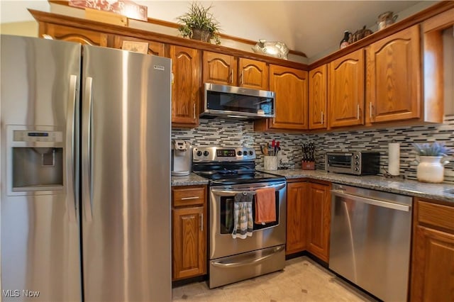 kitchen featuring stainless steel appliances, backsplash, brown cabinetry, and a toaster